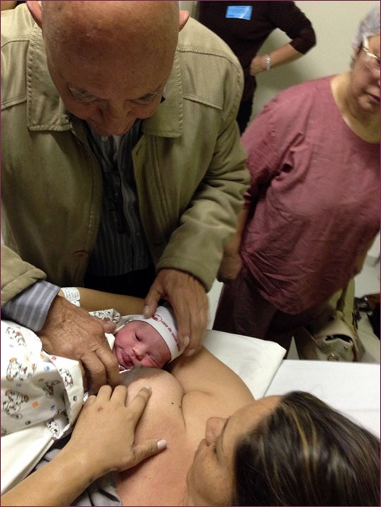 Meu pai, colocando Dora pra mamar logo após o parto